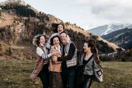 Familienportrait mit sechs Personen herzlich umarmt und lachend vor Berglandschaft, ausgelassene Stimmung in der Natur der Salzburger Alpen, Familienshooting, Familienfotografie Salzburg von Leonie Unterkofler